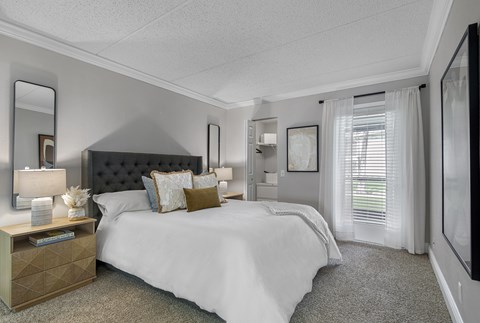 A bedroom with a large bed and a dresser with a mirror.
