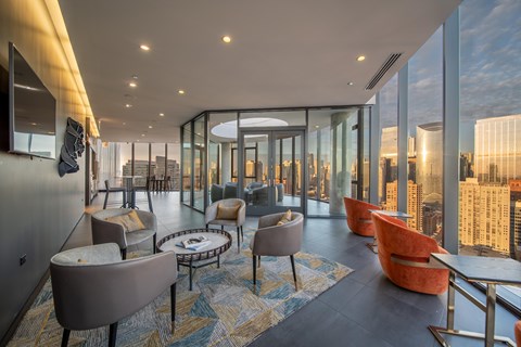 A modern living room with a view of the cityscape outside the large windows.