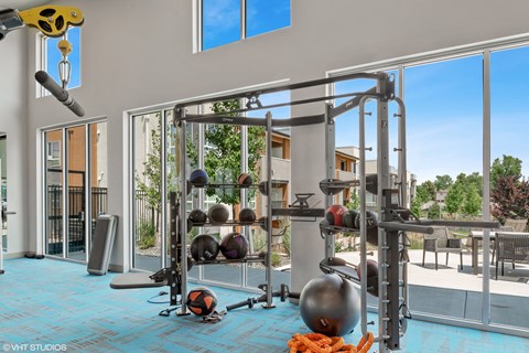 A gym with a blue floor and a variety of equipment.