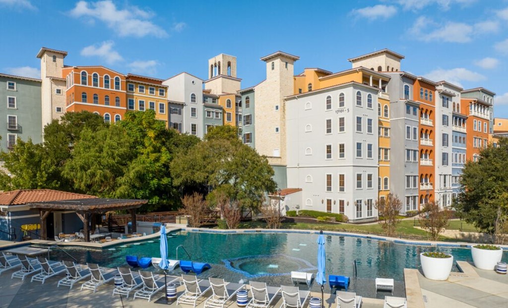 a swimming pool at a resort with chairs around it