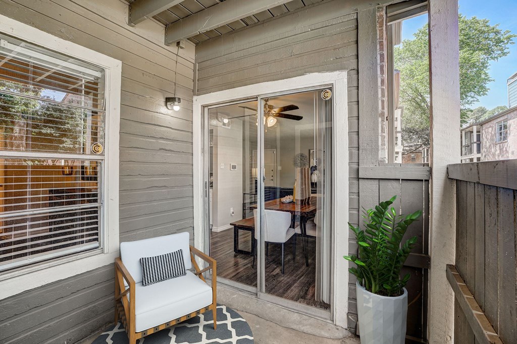 a small porch with a chair and a sliding glass door