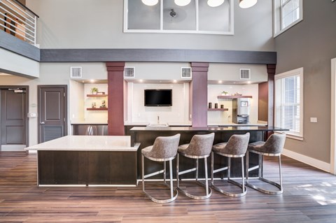 a kitchen with stools and a counter with a bar and chairs