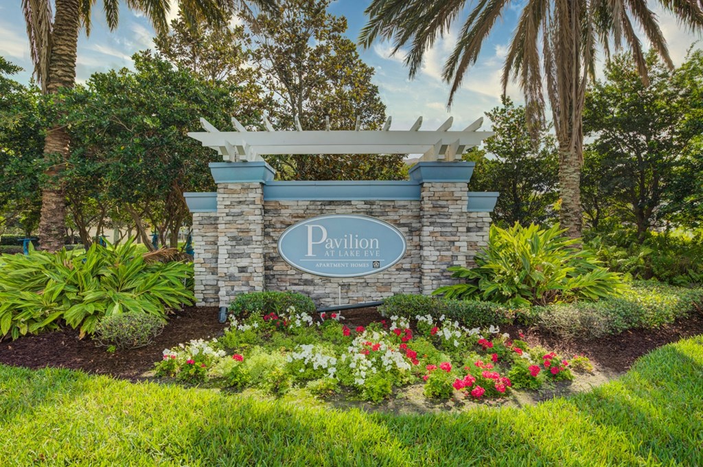 an image of the pavilion entrance sign with flowers and trees in the background