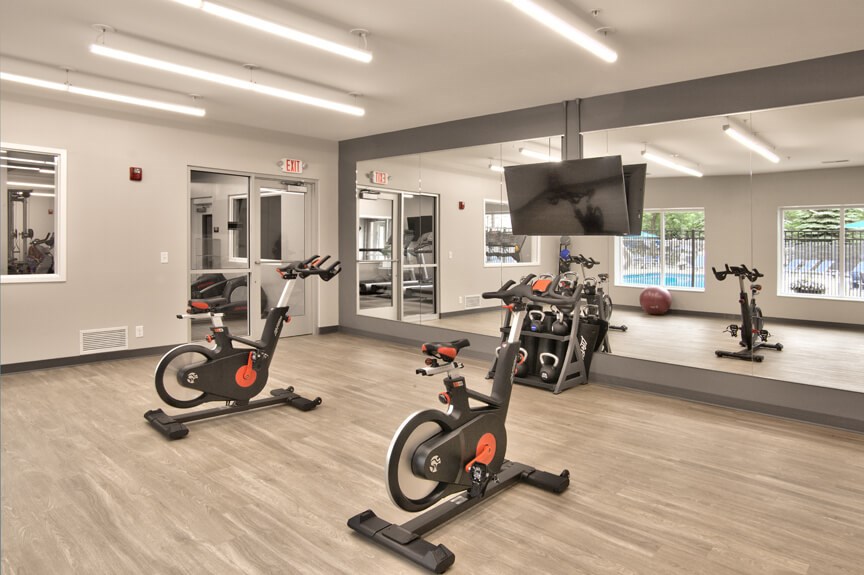 a gym with exercise equipment and a tv in a building