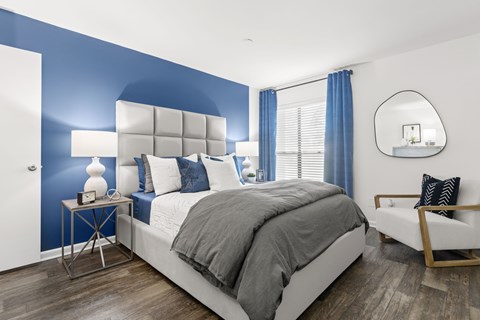 a bedroom with a blue accent wall and a white bed