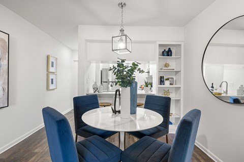A dining room with a white table and blue chairs.