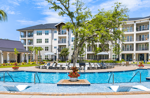 A large white building with a pool in front.