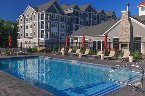 A large swimming pool in front of a resort style building.