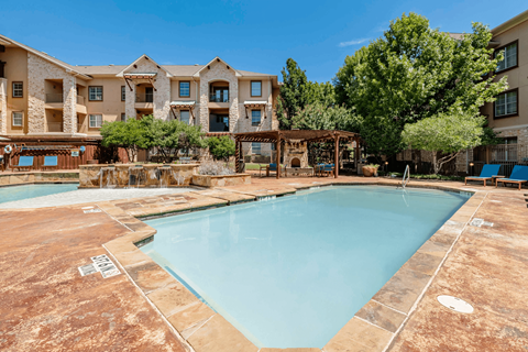 A large swimming pool in front of apartment buildings.