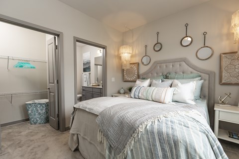 A bedroom with a large bed and a mirror on the wall.
