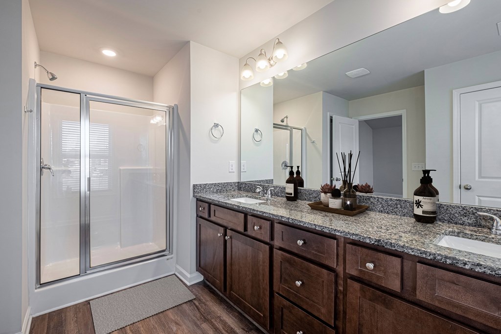 a bathroom with wooden cabinets and a shower and a sink