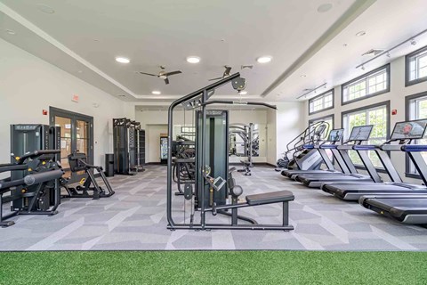 A spacious gym with a variety of equipment including treadmills, elliptical machines, and weight machines.
