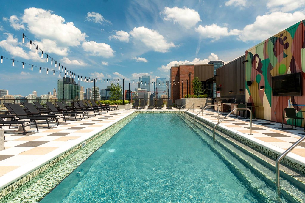 a swimming pool on the rooftop of a building with a city in the background