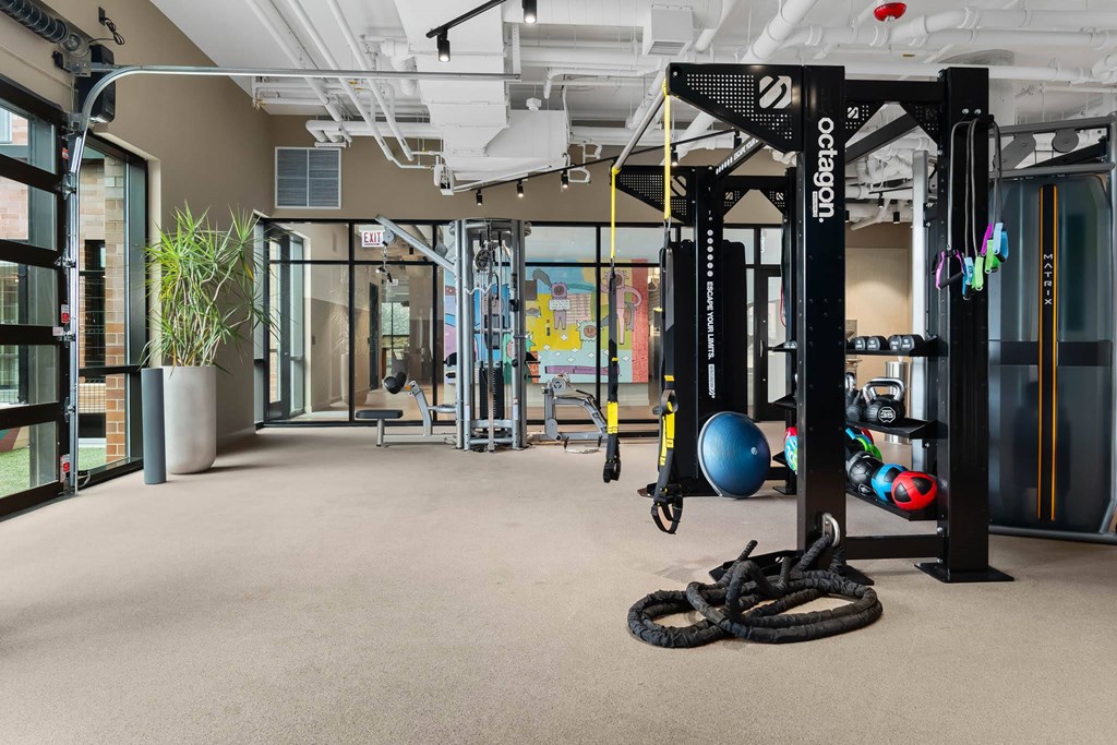 a gym with weights and other gym equipment and glass doors