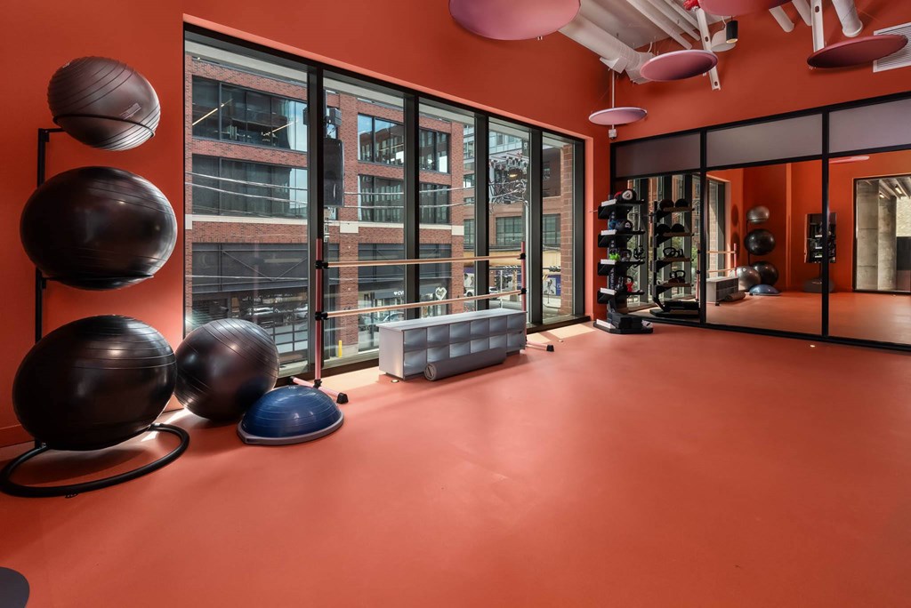 the gym at the building has floor to ceiling windows