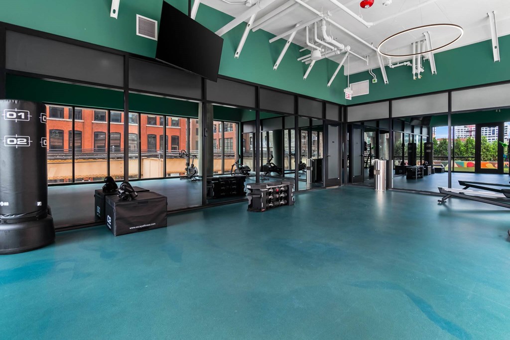 a gym with a blue floor and large windows