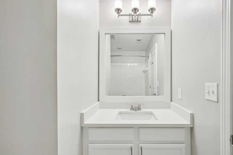 a white bathroom with a sink and a mirror
