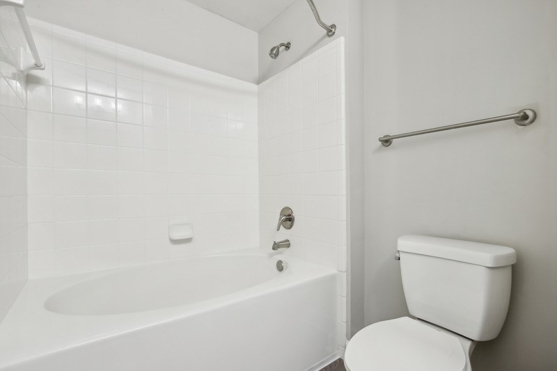a white bathroom with a tub and a toilet