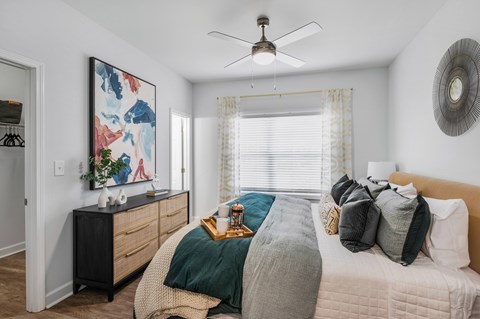 a bedroom with a large bed and a ceiling fan