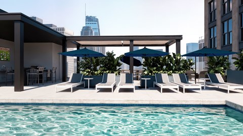 Rooftop swimming pool with lounge chairs, umbrellas and Downtown Phoenix skyline views at Sora Apartments