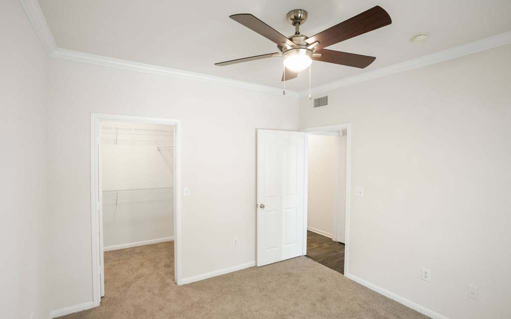 a bedroom with a ceiling fan and closet