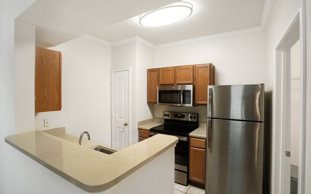 a kitchen with wooden cabinets and stainless steel appliances