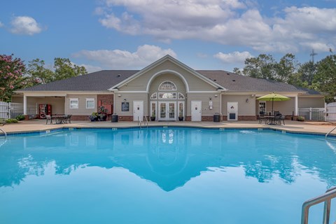 A large swimming pool in front of a house.