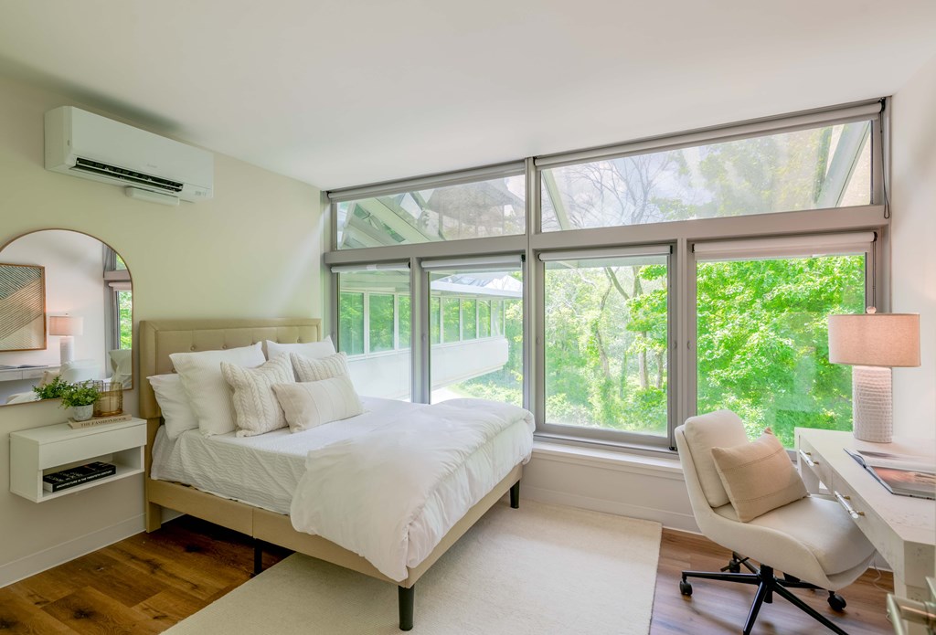 a bedroom with a large bed and large windows