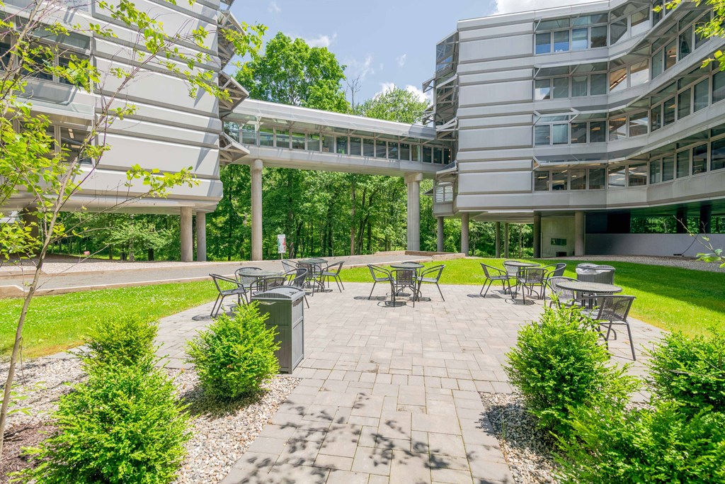 a courtyard with tables and chairs in front of a building