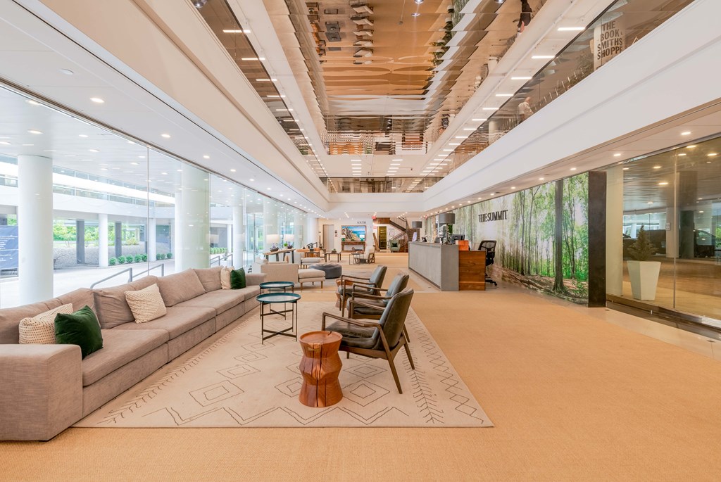a lobby with couches and chairs and a rug