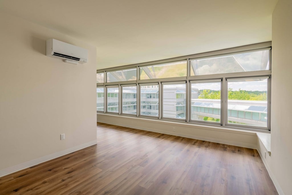 an empty living room with hardwood floors and a large window