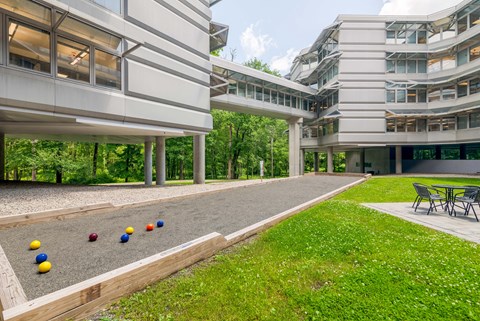 a large building with a yard with balls on the ground