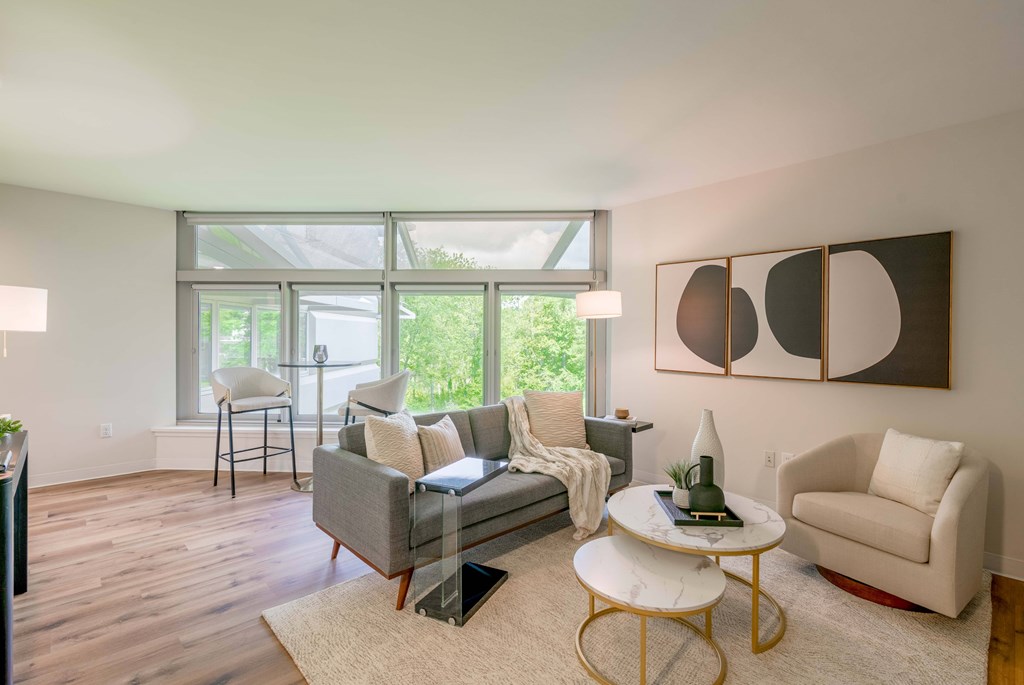 a living room with a couch and chairs and a large window