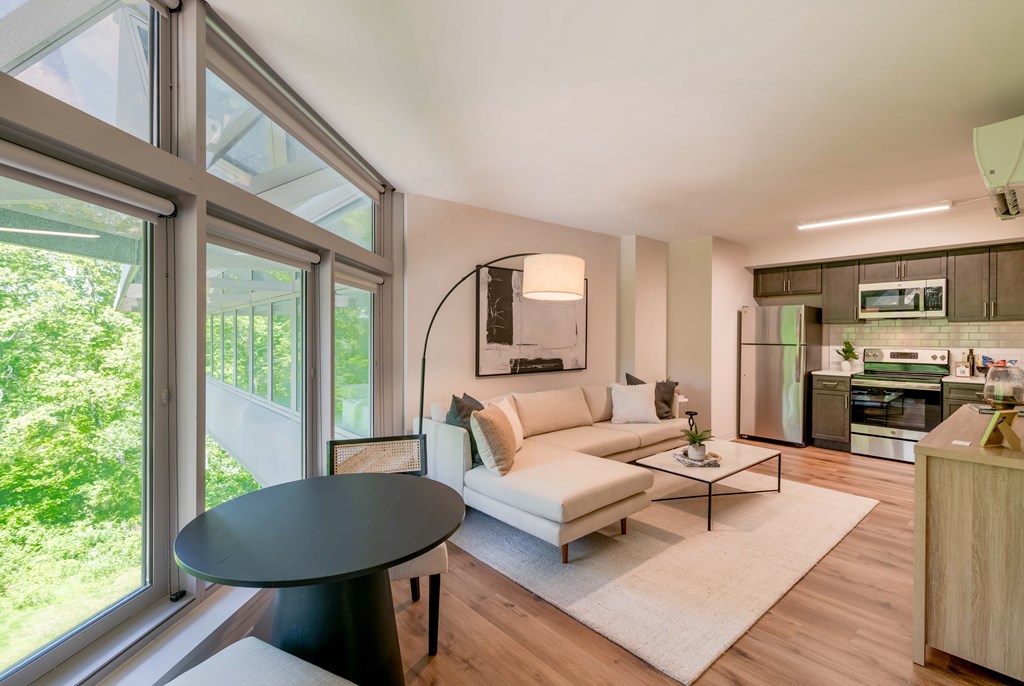 a living room with a couch and a table     and a kitchen