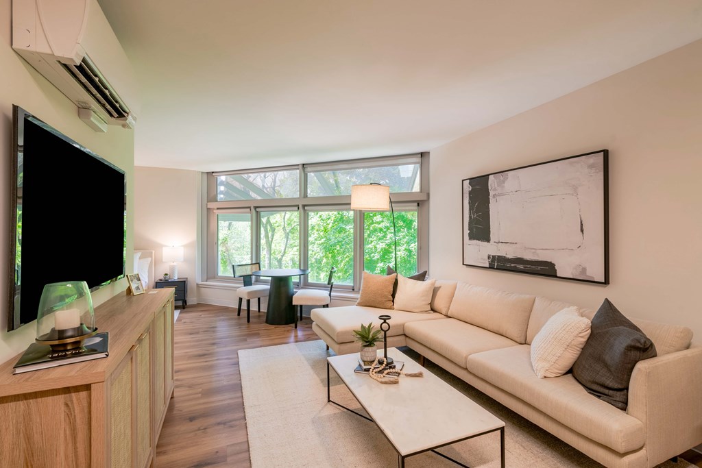 a living room with a couch and a television and a large window