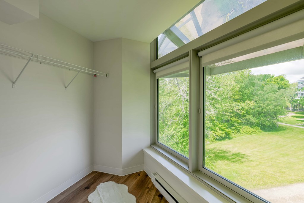 a room with a large window and a view of a grass field