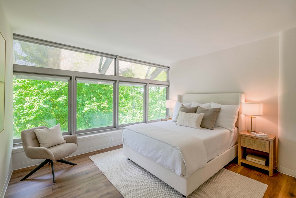 a bedroom with a large bed and large windows
