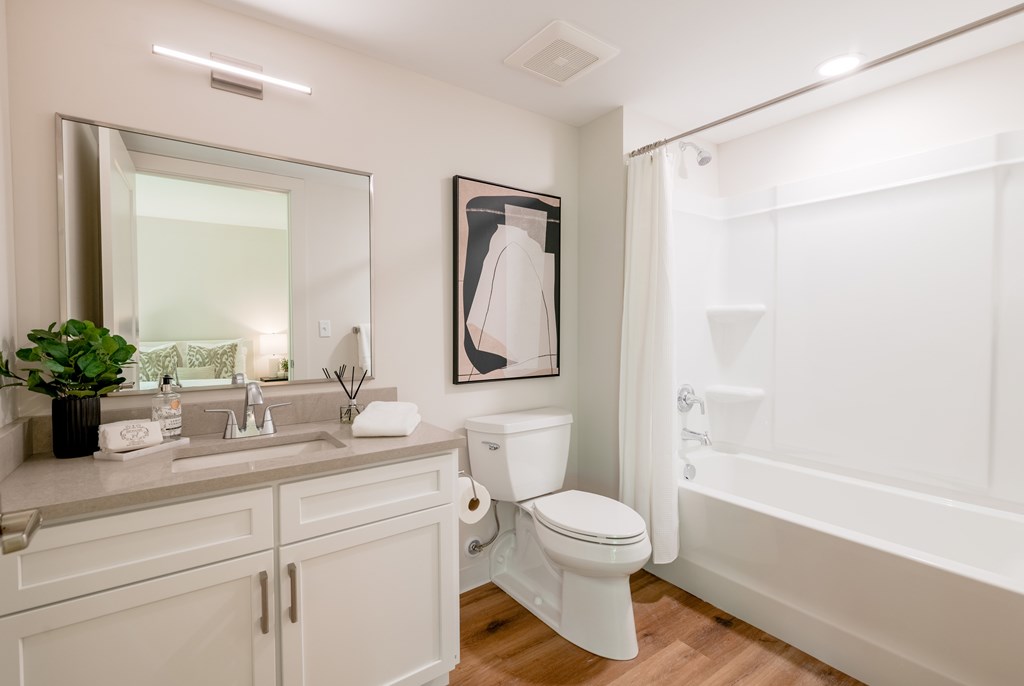 a bathroom with a toilet sink and shower and a mirror