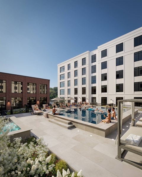 A pool area with people relaxing and enjoying the sun.