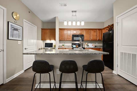 a kitchen with a counter top with three stools