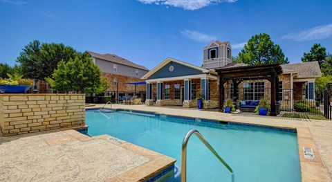 A large swimming pool in front of a house.