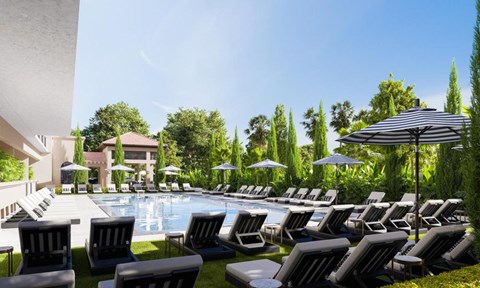 a large pool with lounge chairs and umbrellas