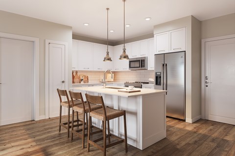 A kitchen with a white countertop and wooden chairs.