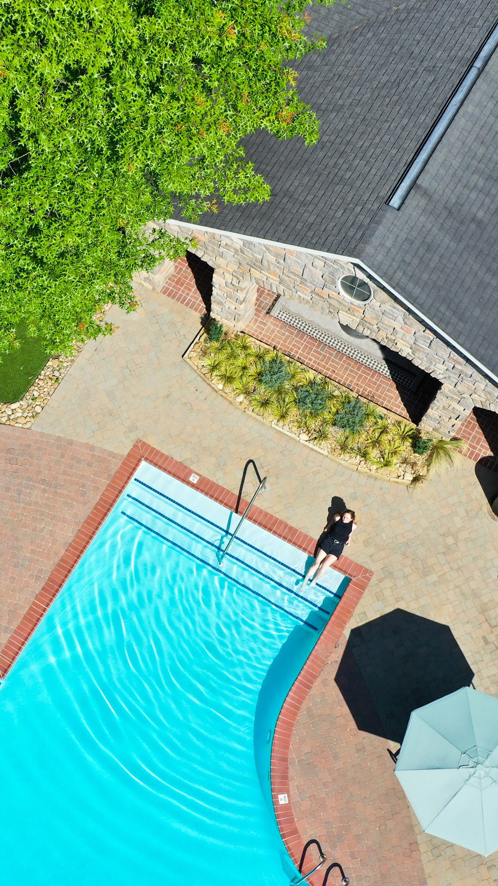 an aerial view of a swimming pool with a person in the water