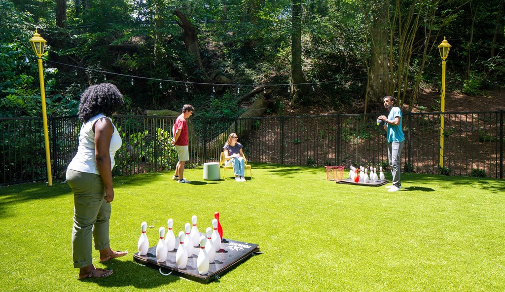 a group of people playing a game of chess on a lawn