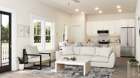 A modern living room with white furniture and a kitchen in the background.