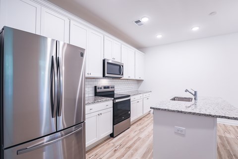 a kitchen with stainless steel appliances and white cabinets