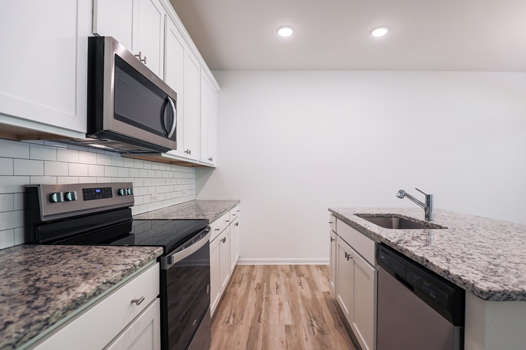a kitchen with marble counter tops and black appliances