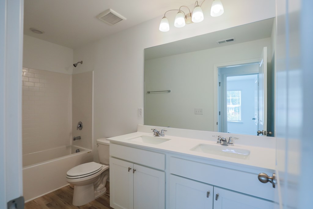 a bathroom with a large mirror and a sink and a toilet