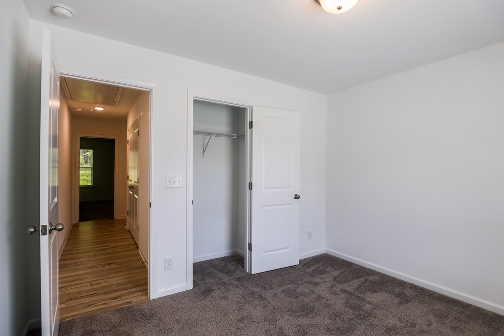 a bedroom with a closet and a door to a bathroom